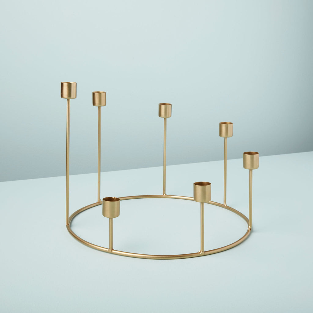 Gold metal candle holder on a light blue background