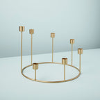 Gold metal candle holder on a light blue background