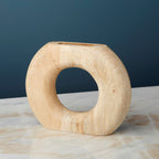Wooden ring-shaped vase on a marble surface with a dark blue background