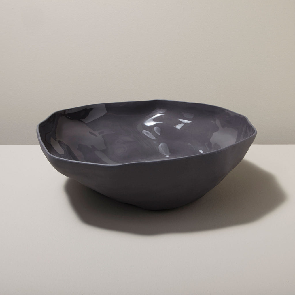 Dark gray ceramic bowl on a light surface with a neutral background
