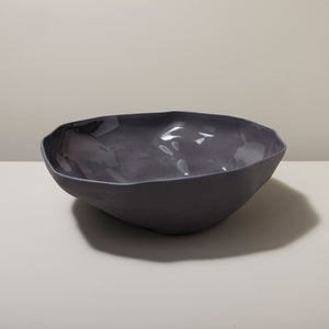 Dark gray ceramic bowl on a light surface with a neutral background