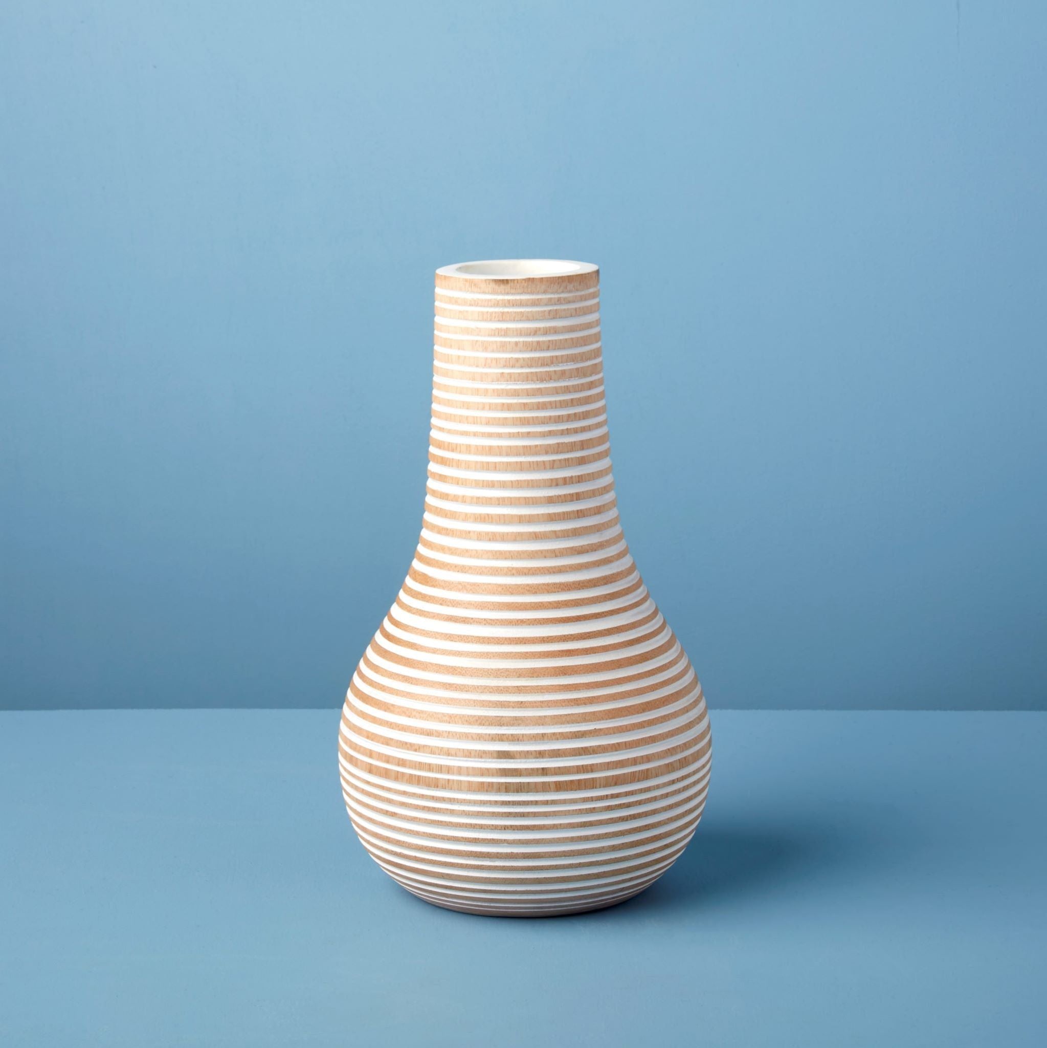Striped wooden vase on a blue background