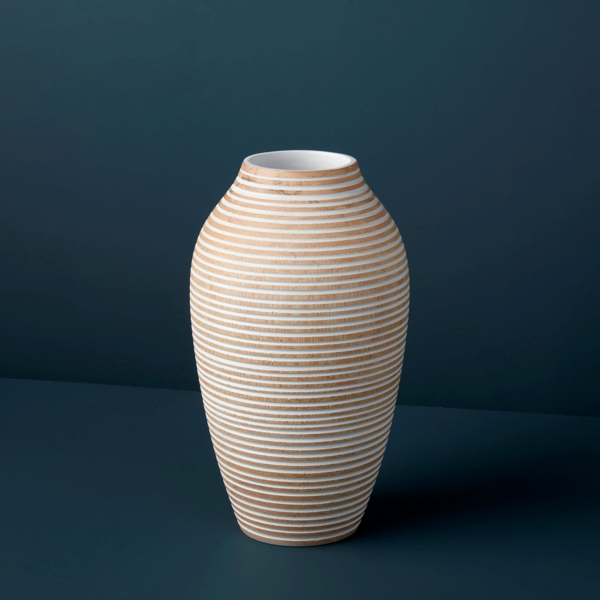 Beige striped vase on a dark blue background