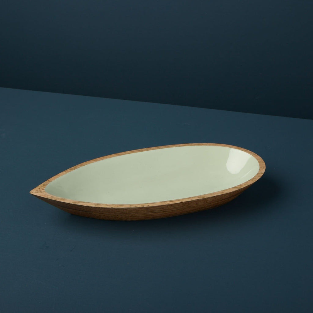 Oval ceramic dish with wooden rim on a dark blue background