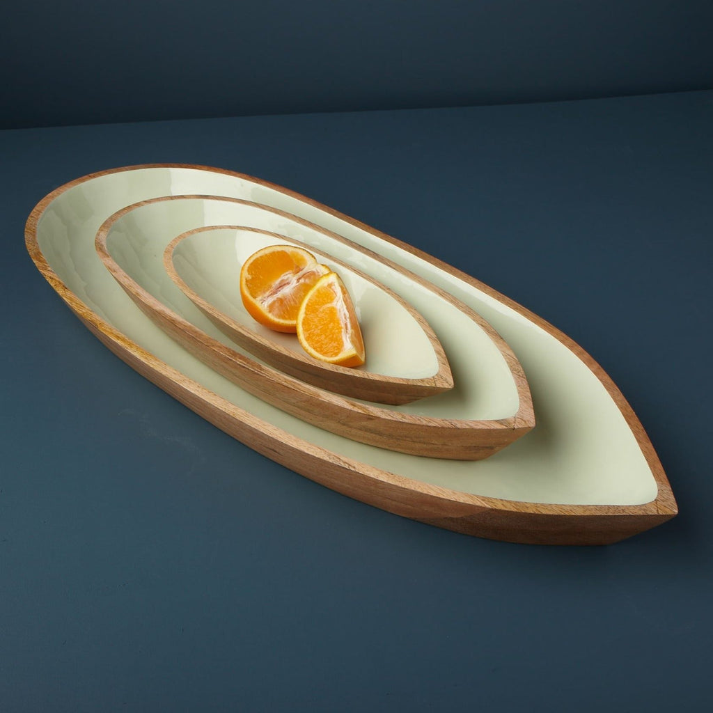 Decorative ceramic dish with concentric circles containing sliced oranges on a dark blue background