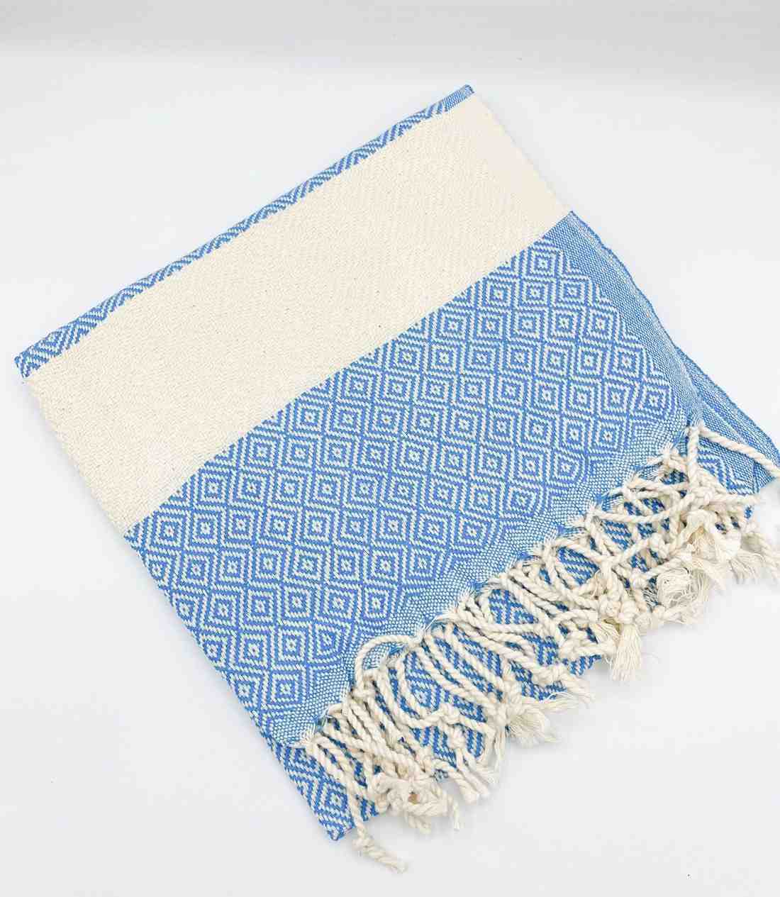 Blue diamond pattern hand towel with white fringe on a plain background