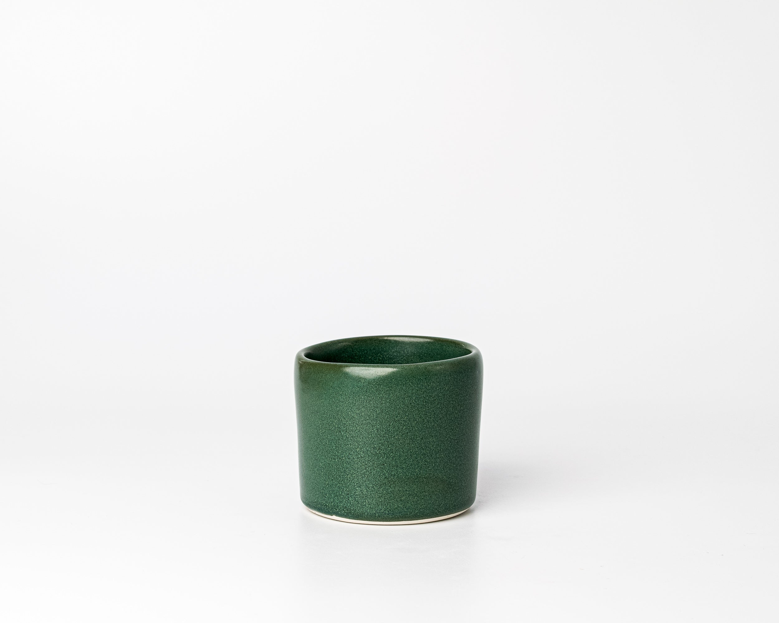 Green ceramic cup on a white background