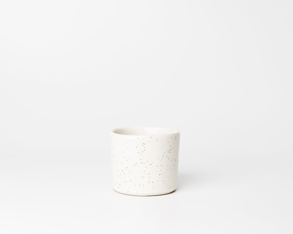 White ceramic pot with speckled texture on a white background