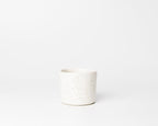 White ceramic pot with speckled texture on a white background