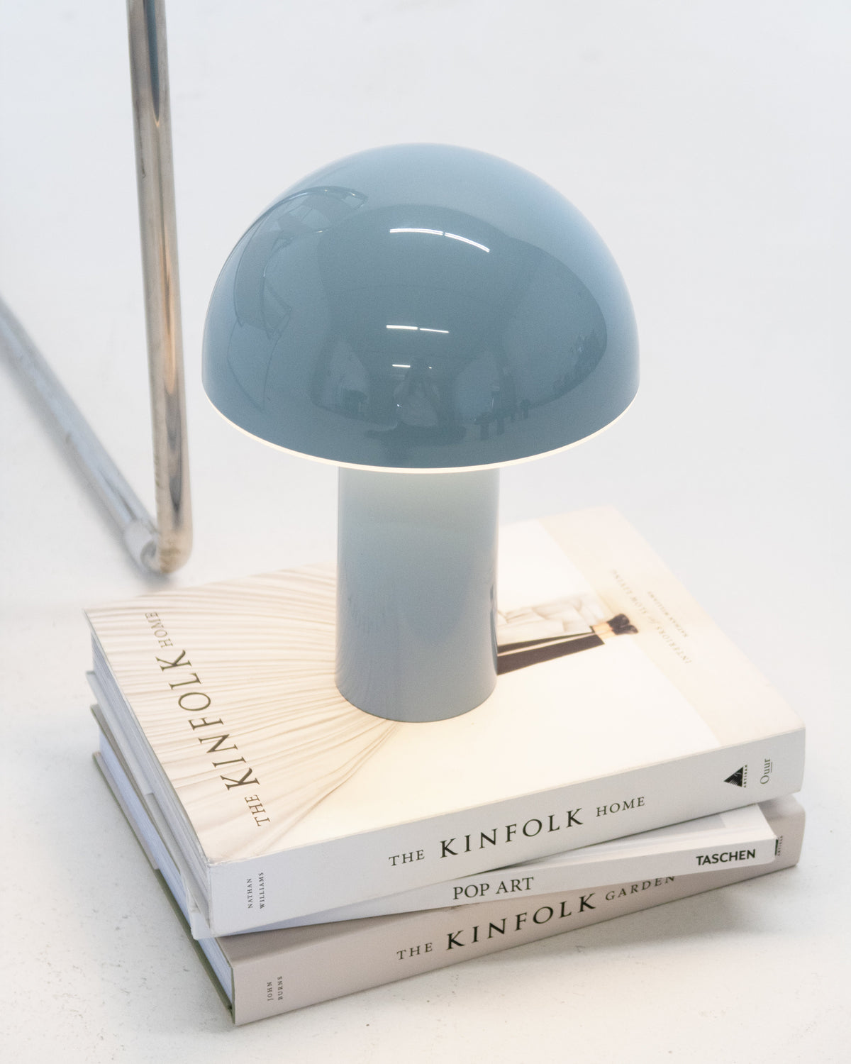 Small blue lamp on a stack of books with a white background
