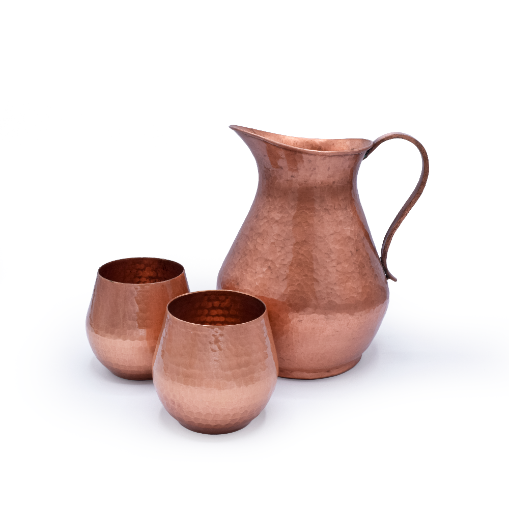 Copper pitcher and two cups on a white background