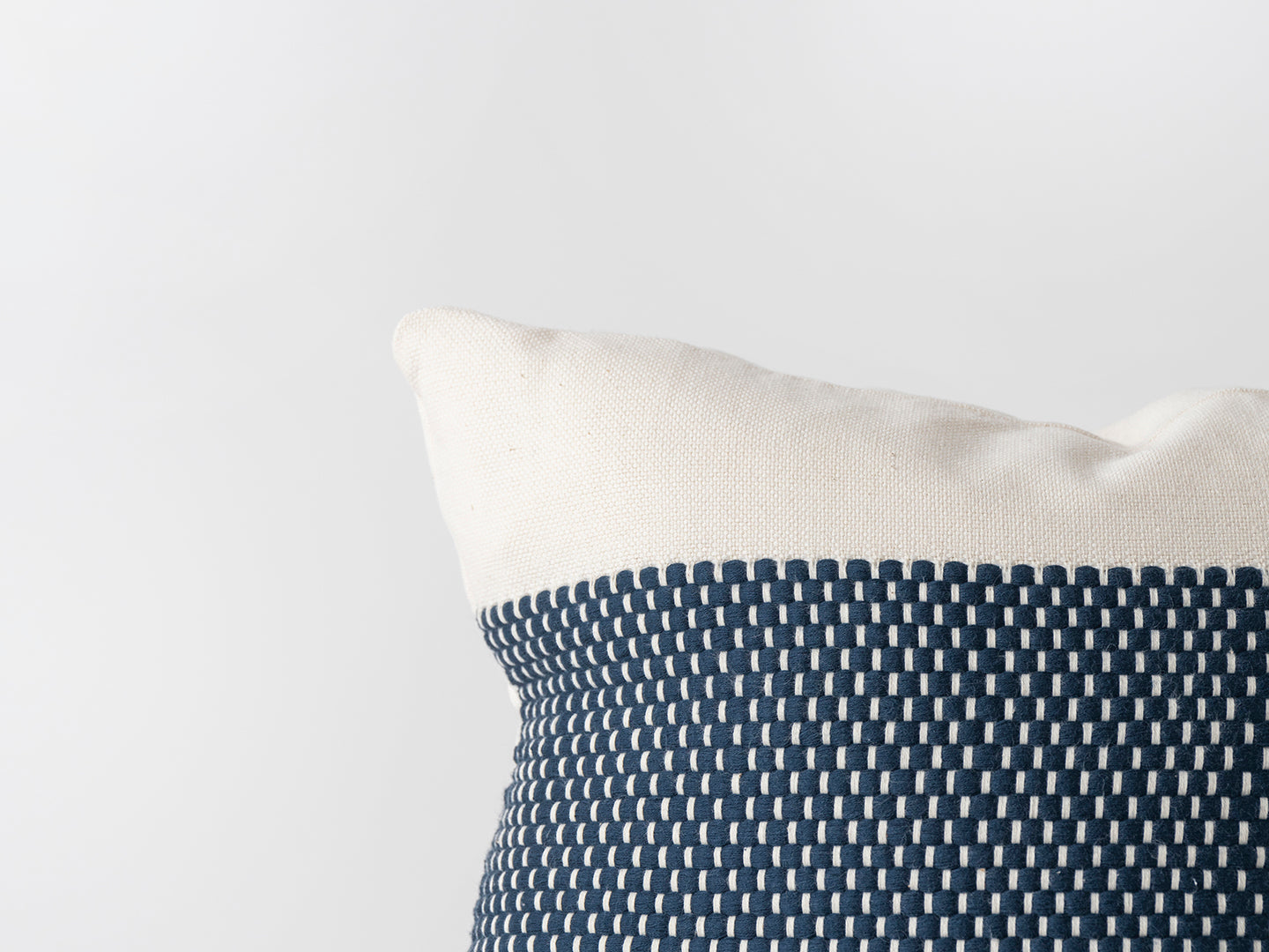 Close-up of a pillow with a blue and white pattern on a light gray background