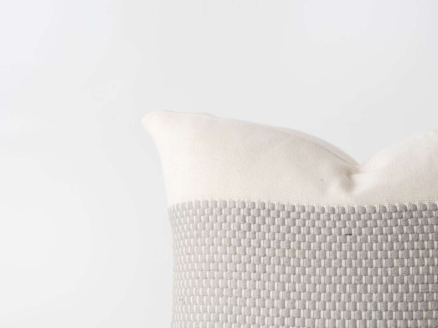 grey textured pillow with a white background
