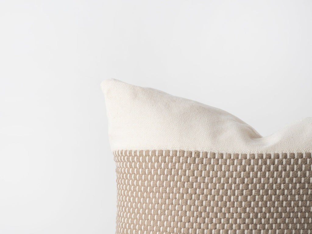Beige pillow with textured pattern on a light gray background