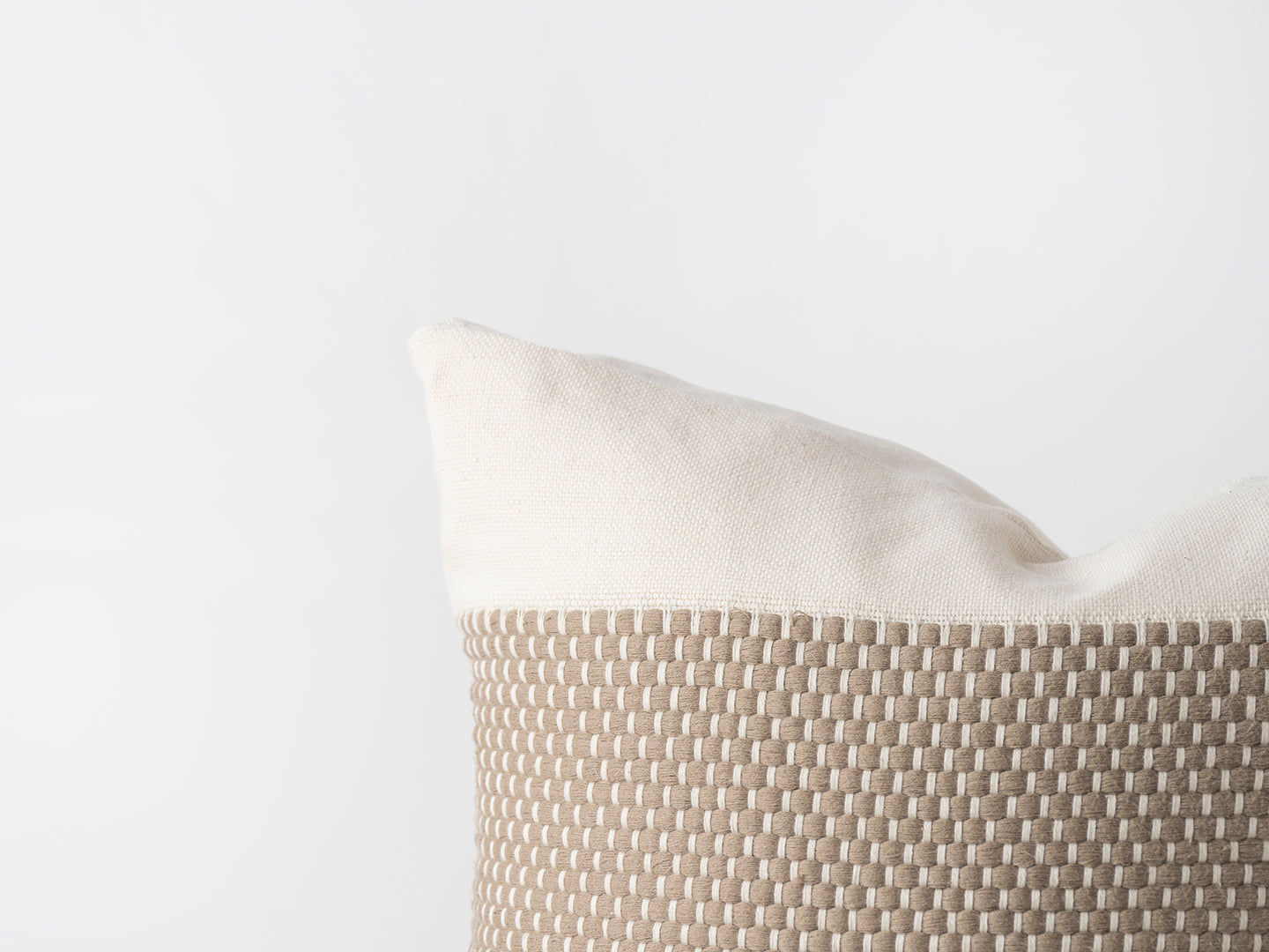 Beige pillow with textured pattern on a light gray background