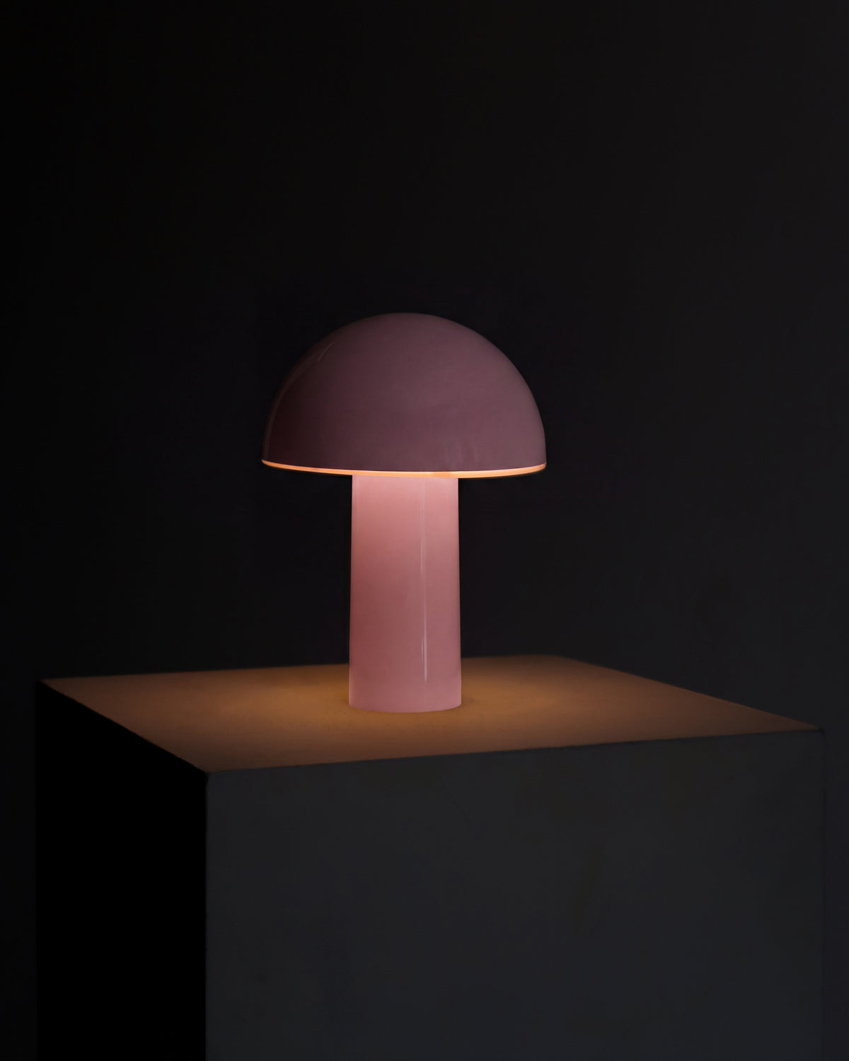 Mushroom-shaped lamp with a pink shade on a black background