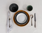 Dinnerware set with bowls, plates, and cutlery on a light gray surface