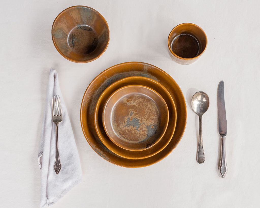Ceramic bowls with silverware on a white surface