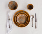 Ceramic bowls with silverware on a white surface