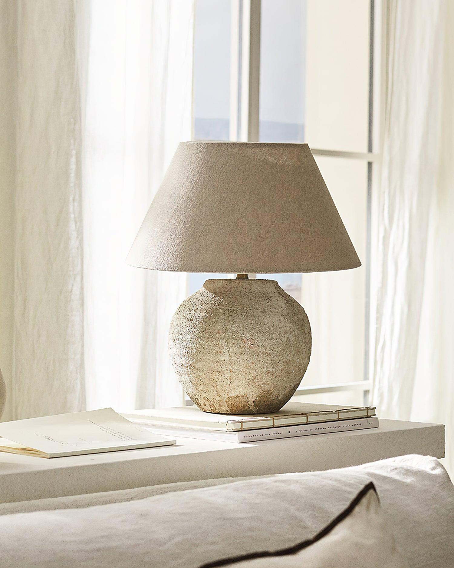 Textured table lamp on a surface with a window in the background