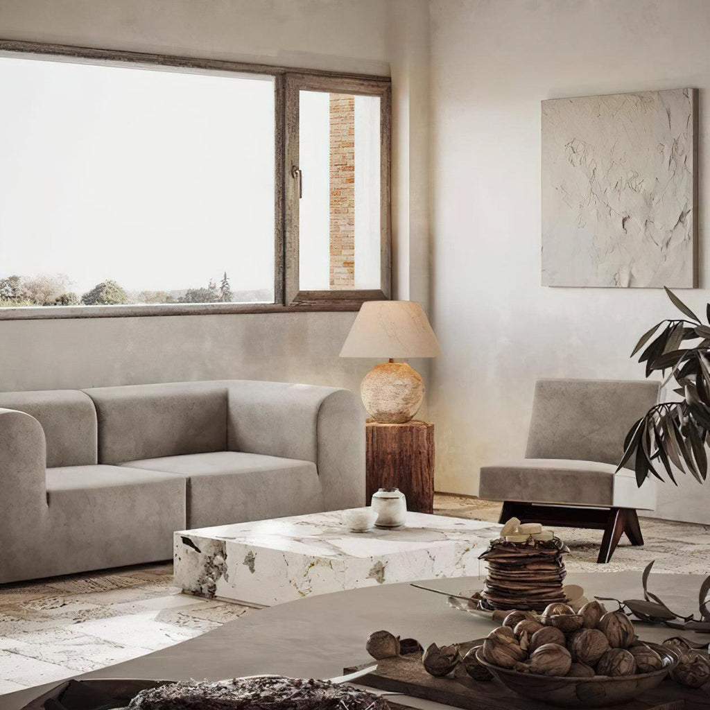 Modern living room with gray sofa, marble coffee table, and decorative elements.
