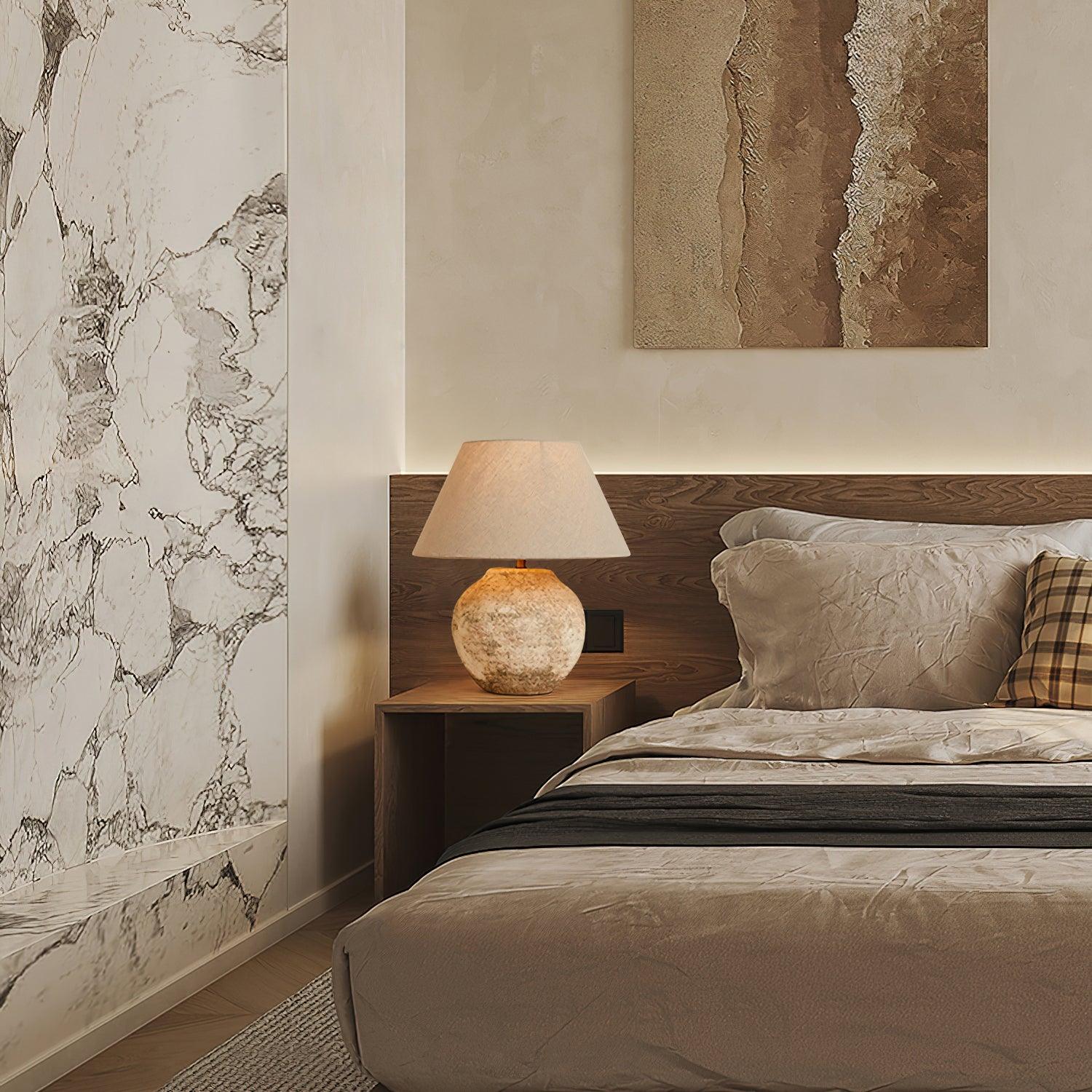 Modern bedroom with marble wall, wooden headboard, and bedside lamp.