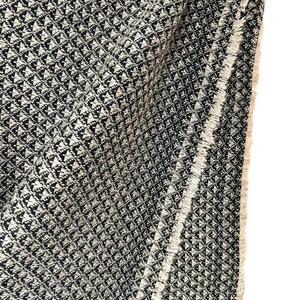 Close-up of a textured black and white patterned rug with a fringe edge.