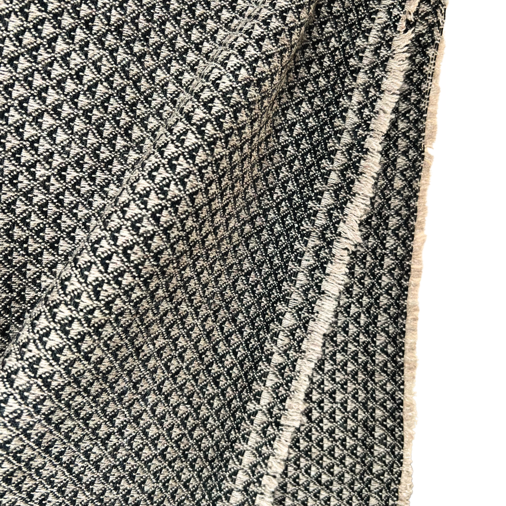 Close-up of a textured black and white patterned rug with a fringe edge.