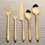 Set of gold cutlery on a textured surface
