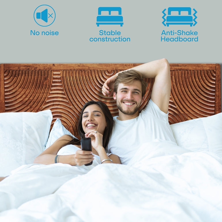 Couple lying in bed with a wooden headboard, featuring icons for no noise, stable construction, and anti-shake headboard.