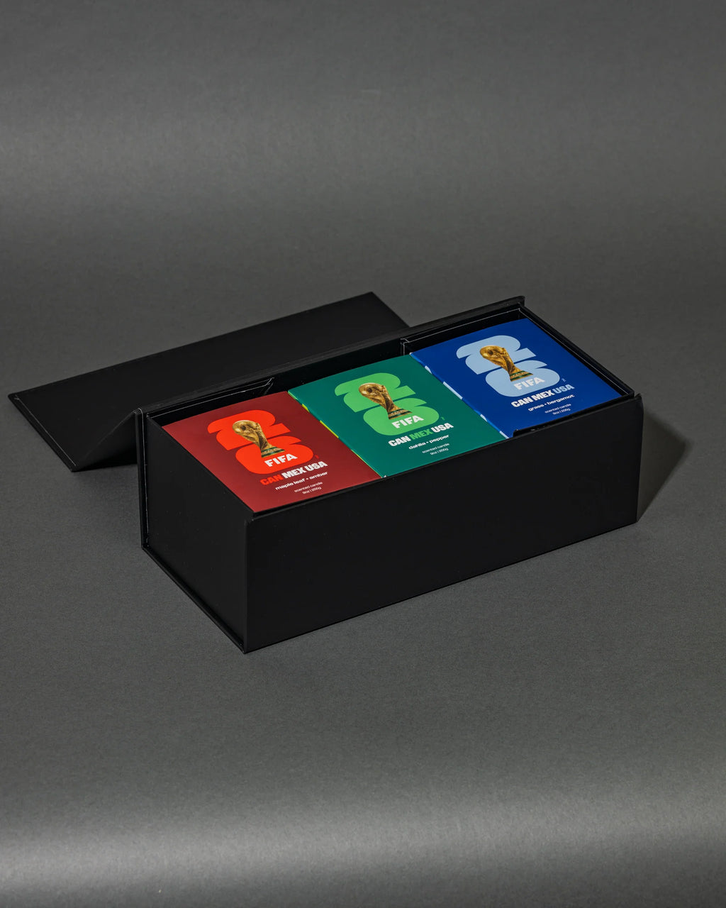 Three colorful candle boxes in a black box on a gray background