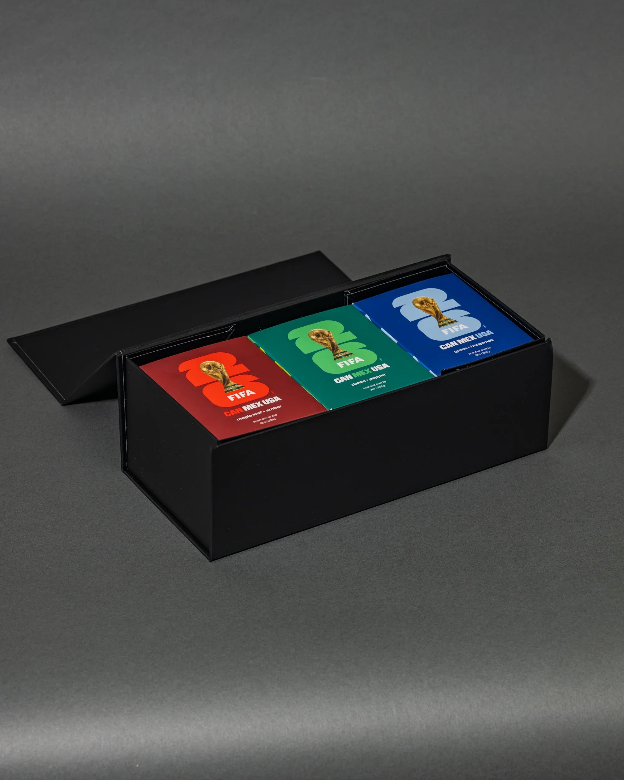 Three colorful candle boxes in a black box on a gray background