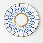 Decorative white plate with blue geometric lines and gold rim on a white background