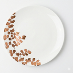 White plate with gold leaf design on a white background
