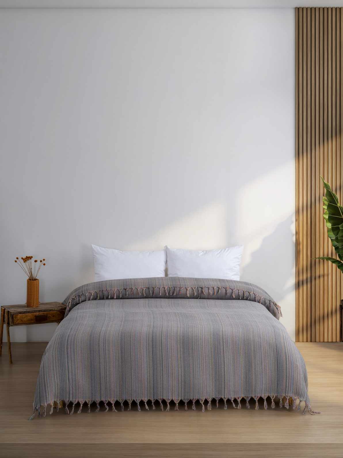 Gray king size blanket with fringes on modern bed, minimal bedroom décor
