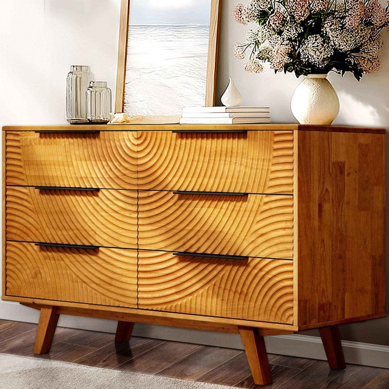 Wooden dresser with wavy grain design in a room setting.