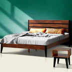 Wooden emery bed with bedding and a nightstand against a teal wall
