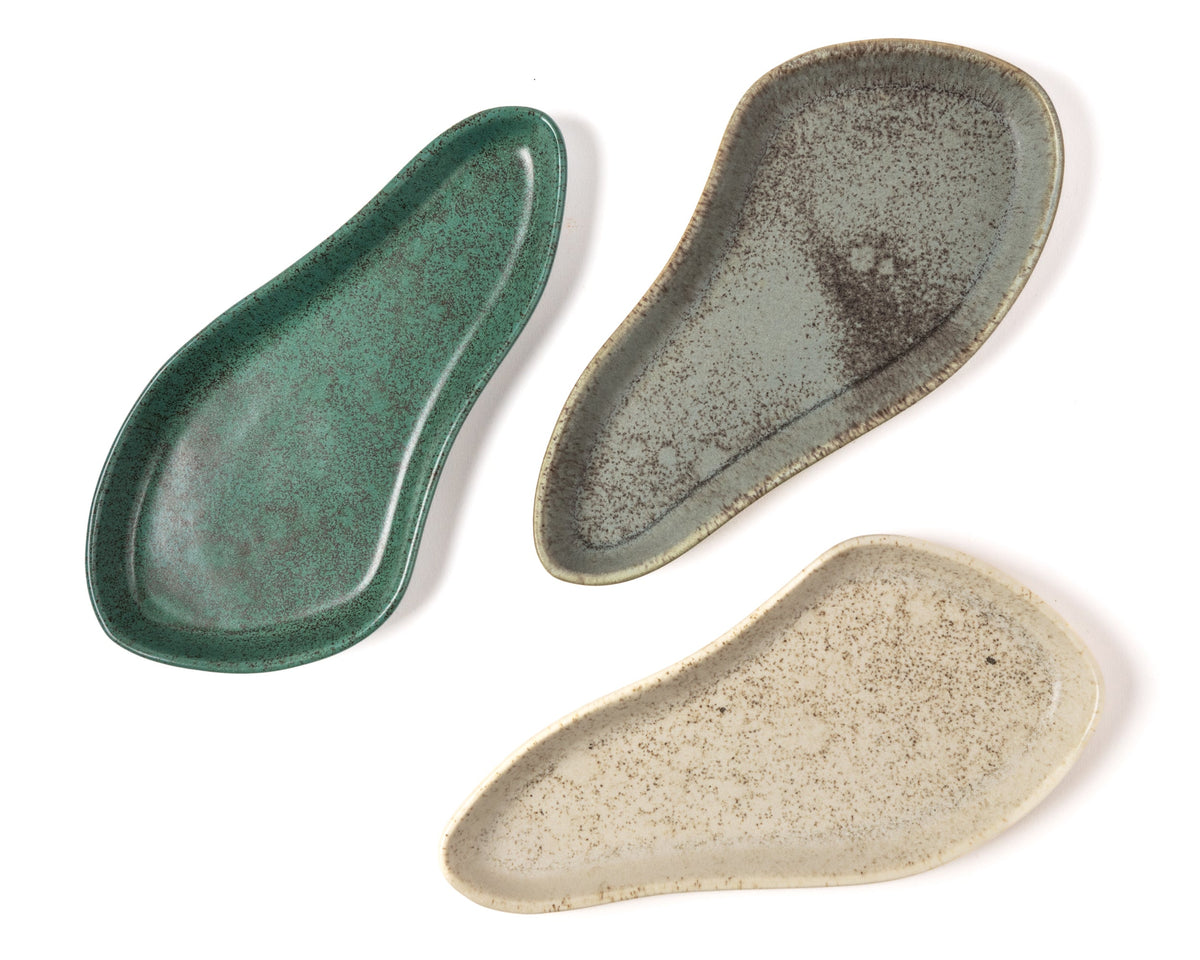 Three ceramic trays in green, gray, and beige on a white background