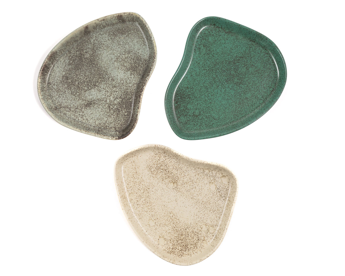 Three ceramic plates in green, beige, and gray on a white background