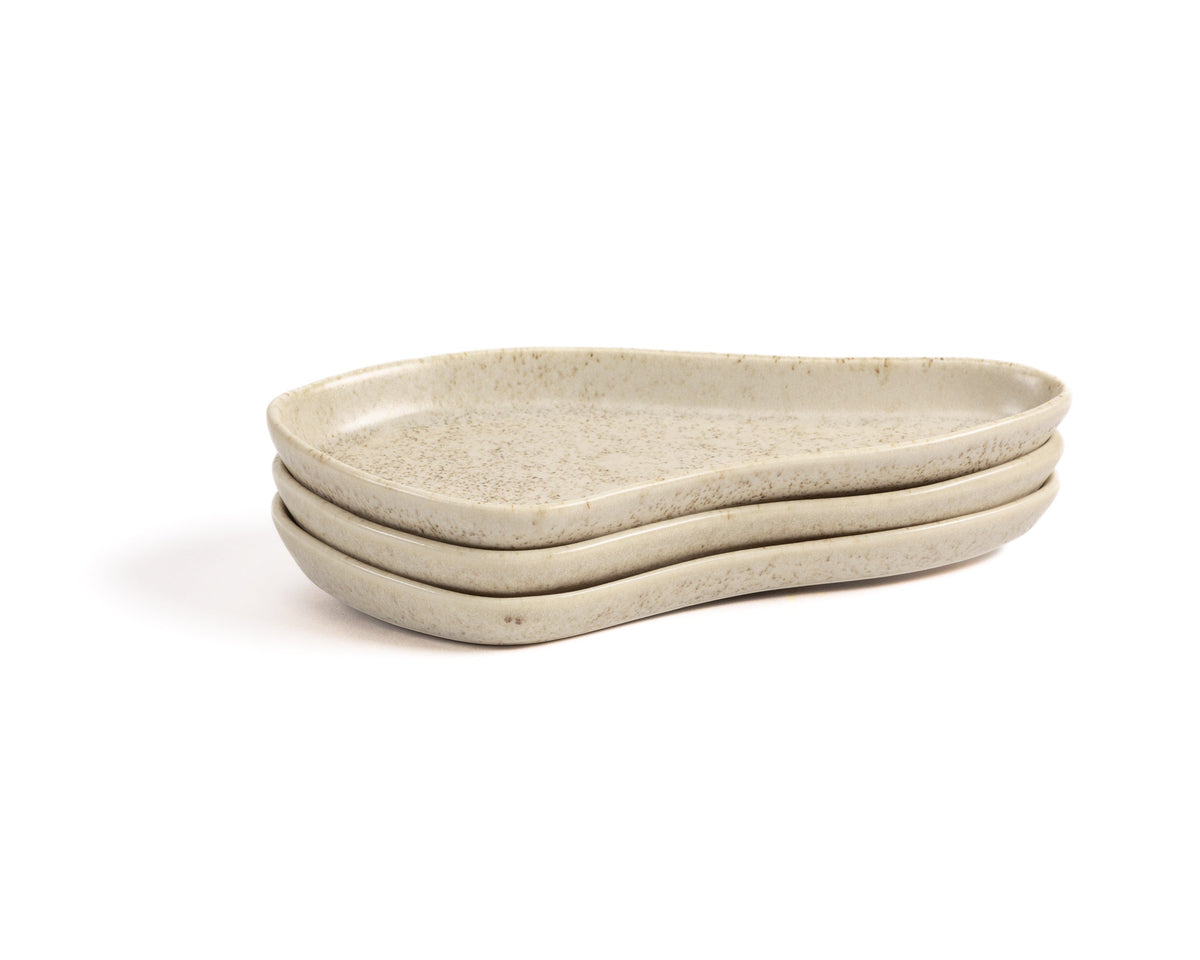 Three beige ceramic trays stacked on a white background