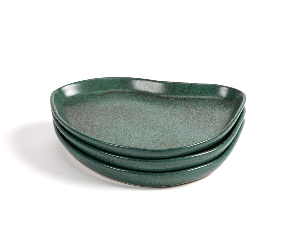 Set of three green ceramic plates on a white background
