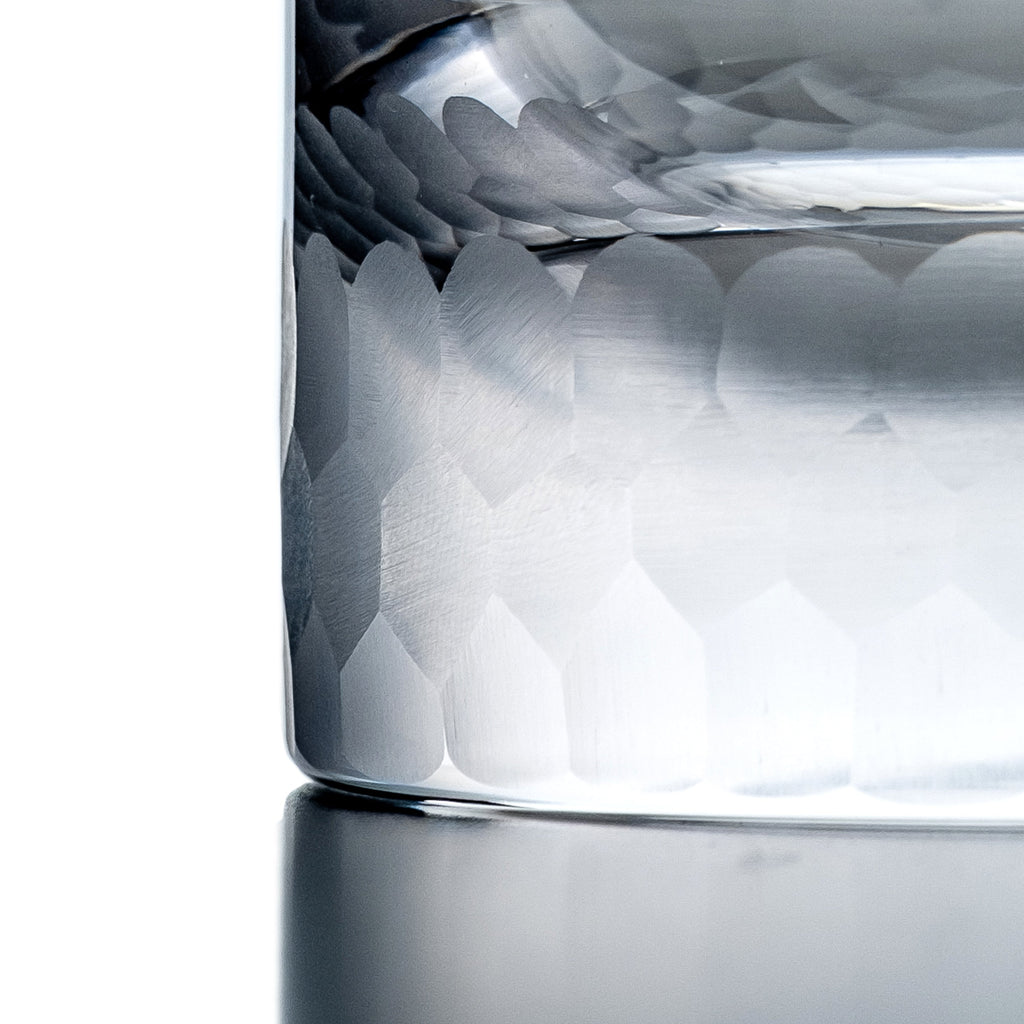 Close-up of a clear glass with wavy design on a white background