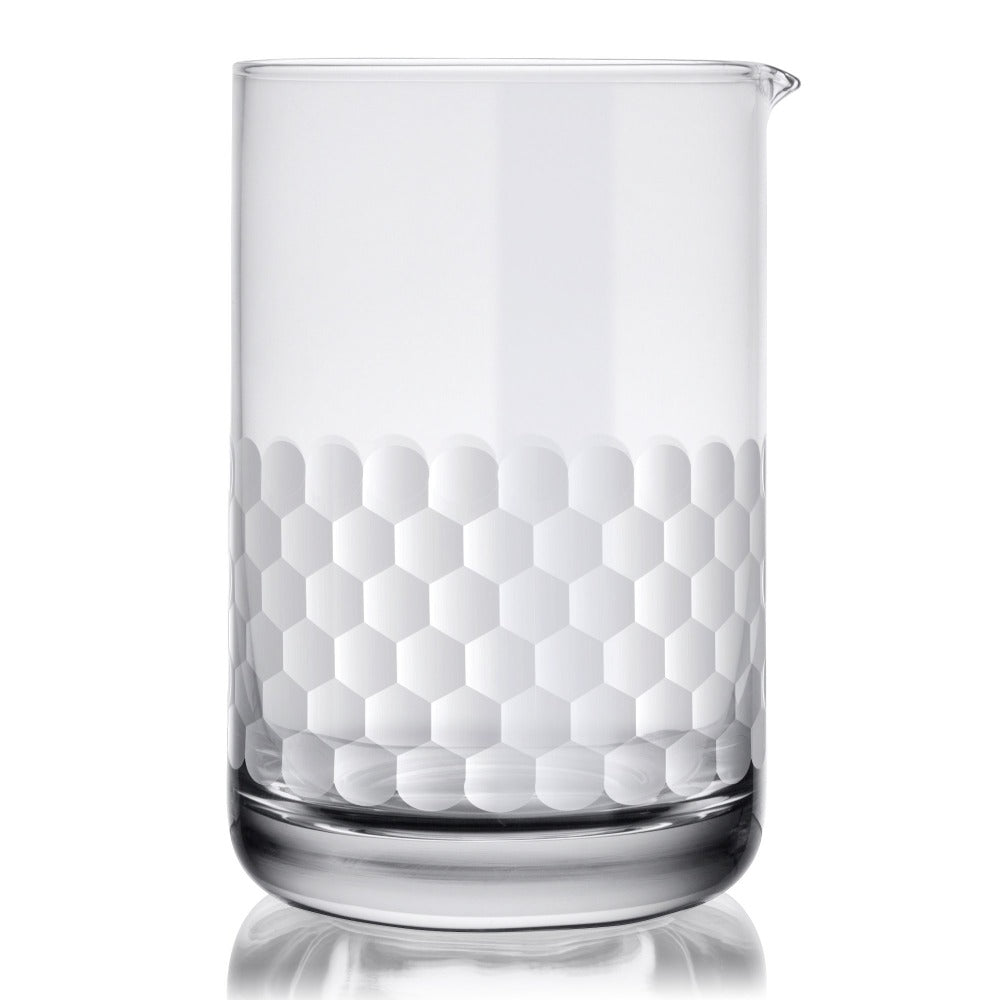 Clear cocktail mixing glass with honeycomb pattern on a white background