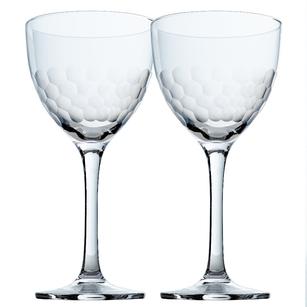 Two clear wine cocktail glasses with textured design on a white background