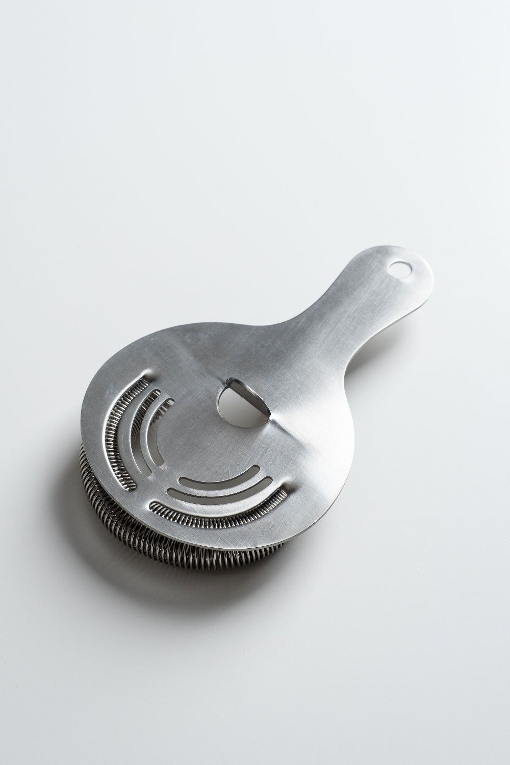 Metallic kitchen strainer on a light gray background