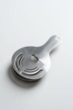 Metallic kitchen strainer on a light gray background