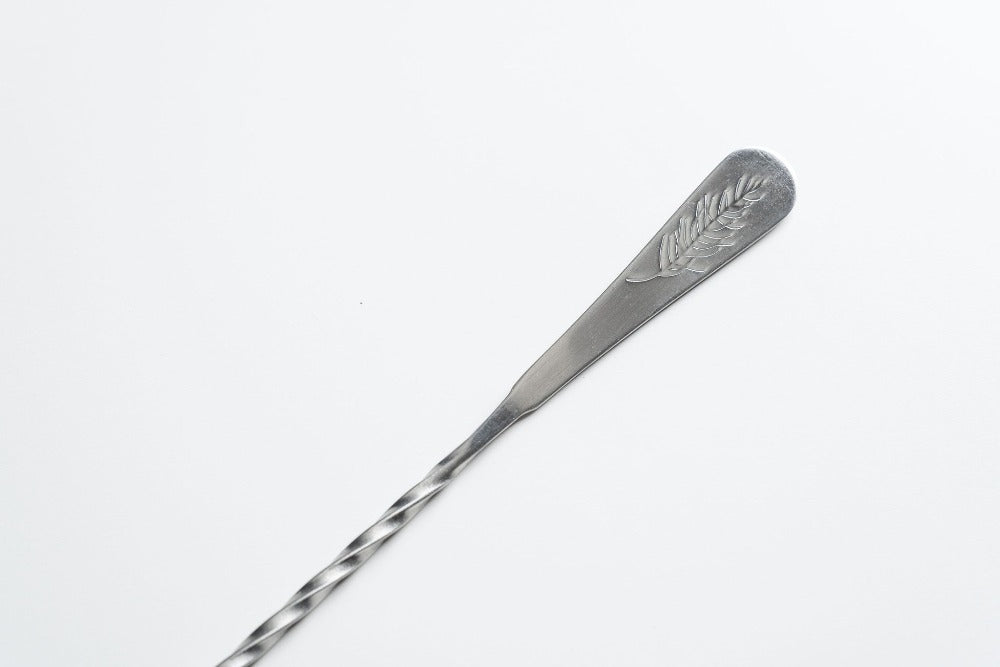 Silver spoon with engraved design on a white background
