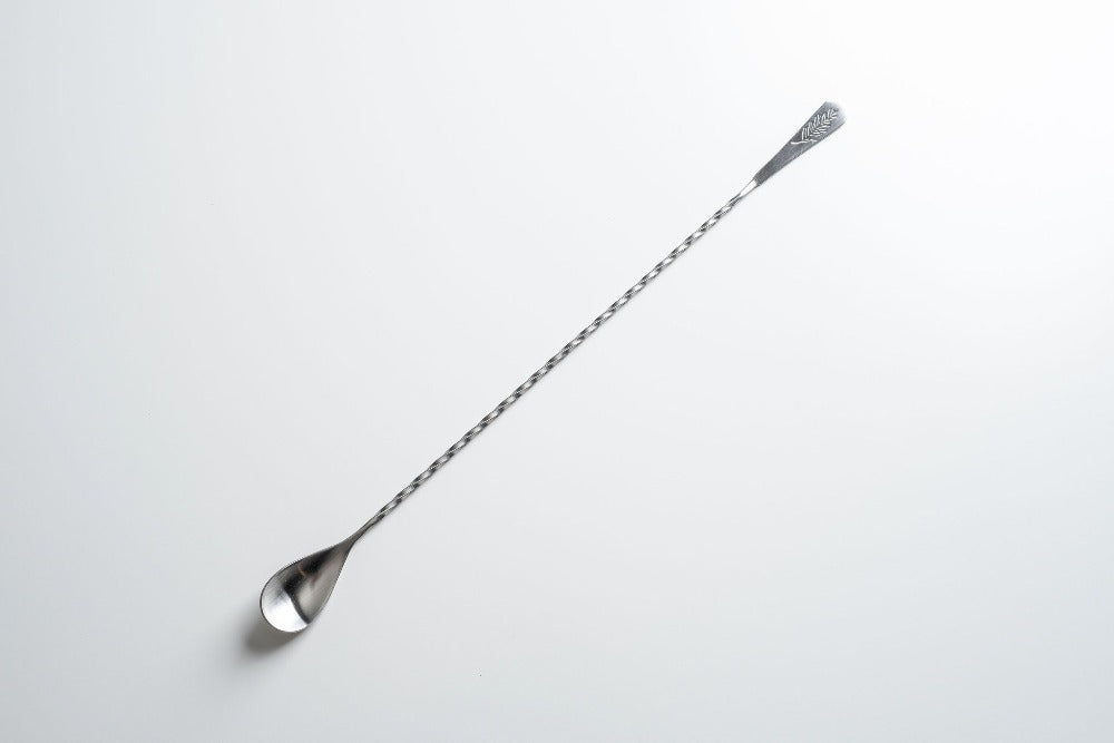 Metallic mixing spoon on a white background