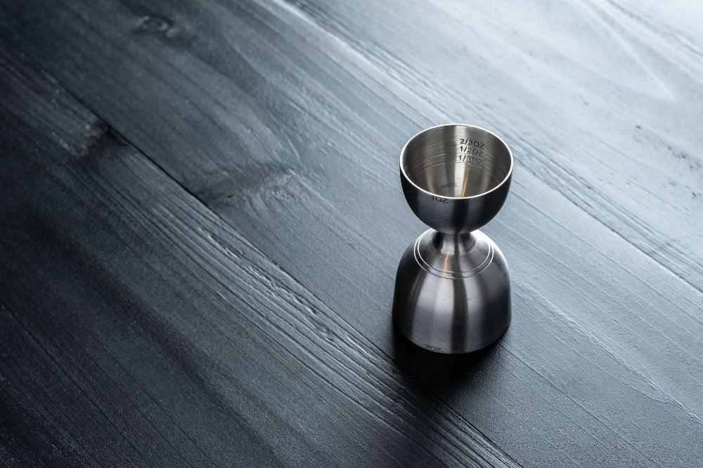 Metallic jigger on a wooden surface
