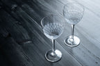 Two crystal glasses on a wooden surface